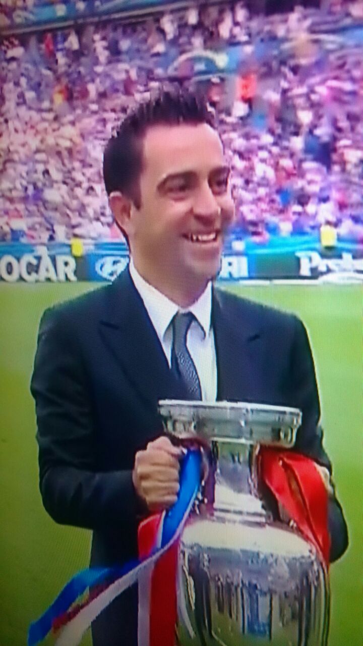 Spain legend Xavi unveils the trophy.