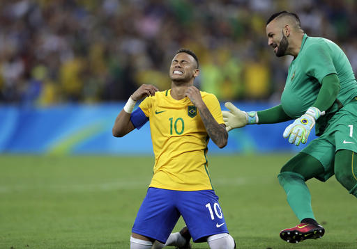 Brazil's Neymar cries as he kneels down to celebrate with teammate goalkeeper Weverton