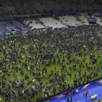 Spectators gather on the pitch of the St