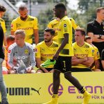 Dembele walks towards his seat as his Dortmund team-mates wait for the photoshoot session