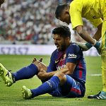 Luis Suarez clutches his right knee in pain during Barcelona’s defeat to Real Madrid