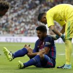 Luis Suarez clutches his right knee in pain during Barcelona’s defeat to Real Madrid