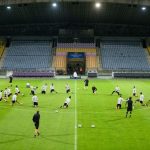 The squad conduct a drill around the centre circle at the stadium