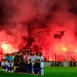 Marseille supporters light flares as players pose before the start of the game